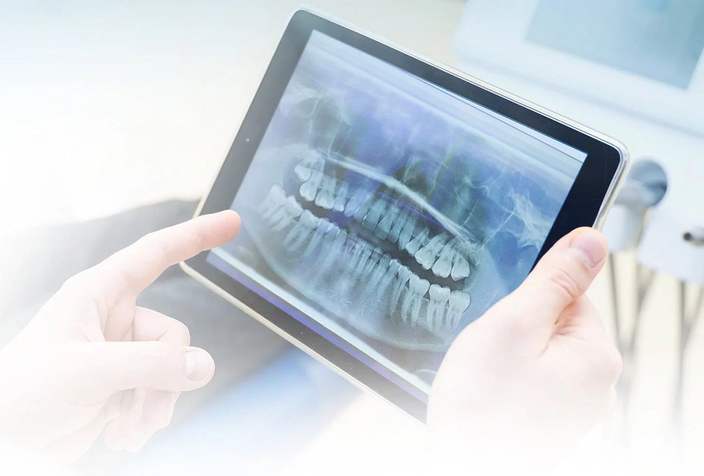 Zahnärztin zeigt ein Röntgenbild der Zähne auf einem Tablet